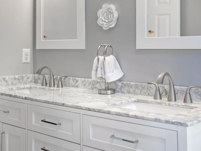 Bathroom vanity with a gray and white marble top and two sinks