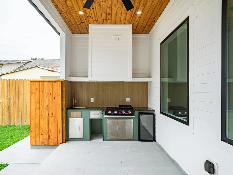 Outdoor kitchen with a built-in grill under a covered patio