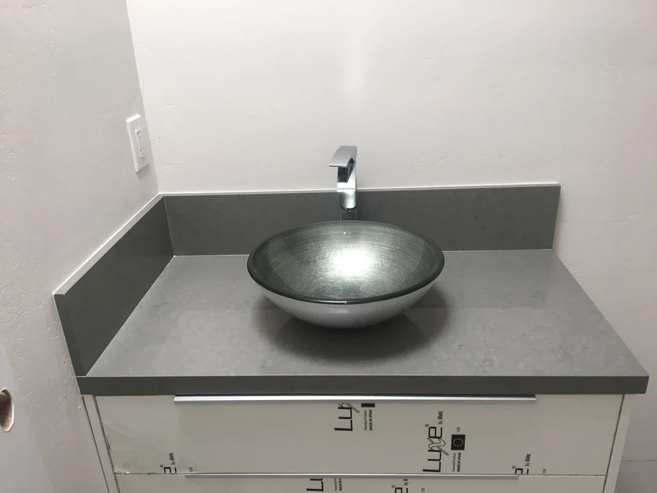 Gray stone bathroom vanity top with a vessel sink