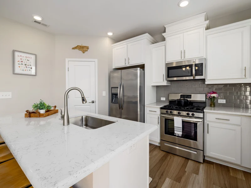 Kitchen island with a white quartz countertop and undermount sink